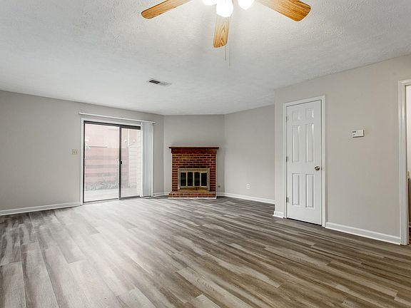 Corner fireplace with gas starter, sliders to fenced in patio