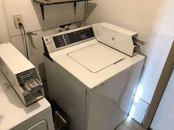 Coin-operated, common laundry room in building.