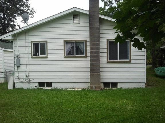 Rear of house. Windows on the left is kitchen, middle is bathroom, and right is rear bedroom. Basement windows are all glass block with vents.