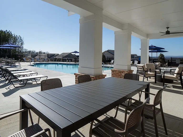 Covered patio on the pool with large table and ample seating to host family and friends.