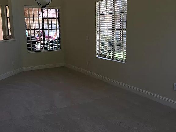 Dining room area attached to living room area. Floor to ceiling windows