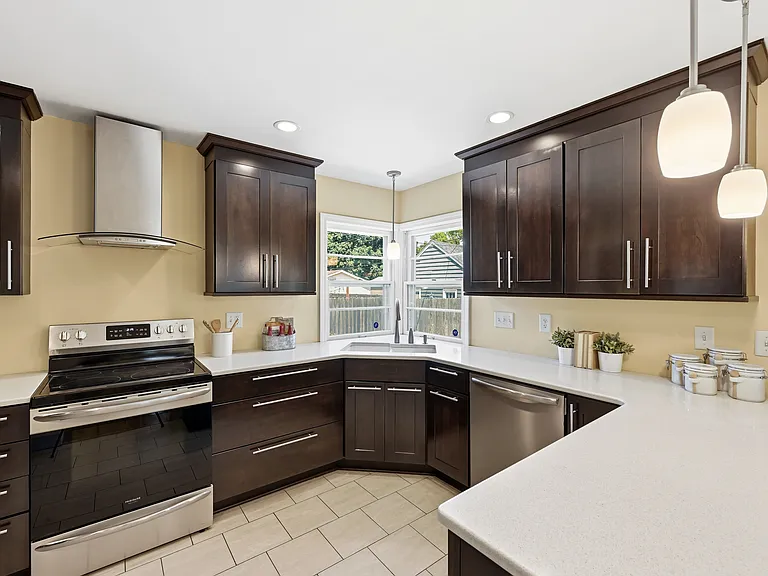 Kitchen with freshly stained cabinets, new dishwasher, stove and gas fireplace