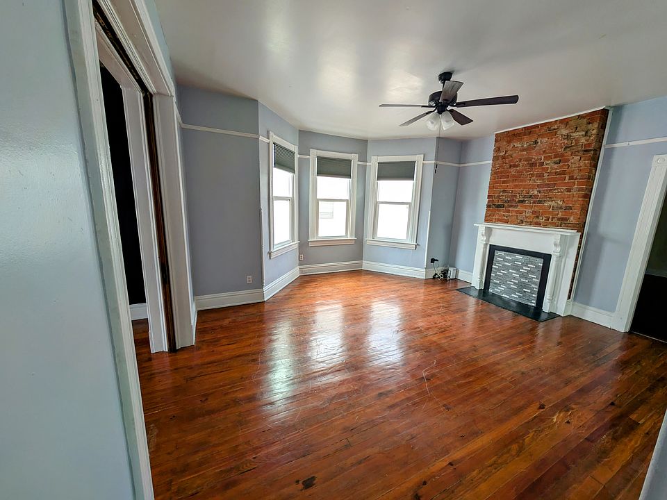 Living room with bay windows and a brick chimney