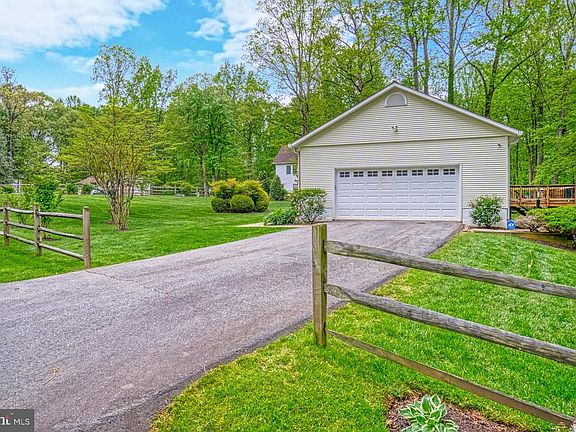 Side-load garage and~split-rail fence~on 3 sides