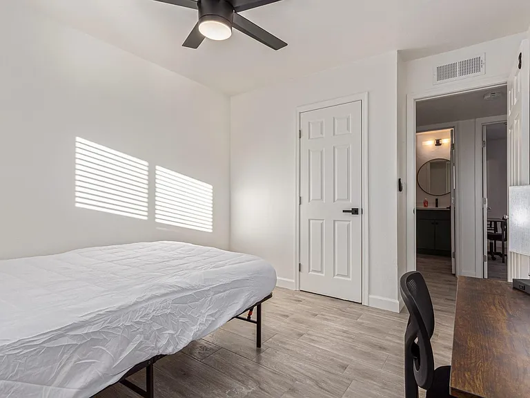 Lots of closet space, desk, chair and ceiling fan.