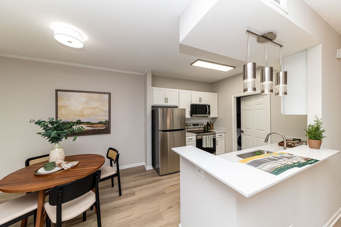 Kitchen with quartz counters, modern cabinetry, & hardwood-style flooring