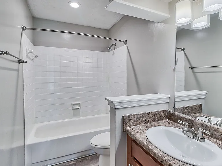 Bright bathroom with tile backsplash and bathtub