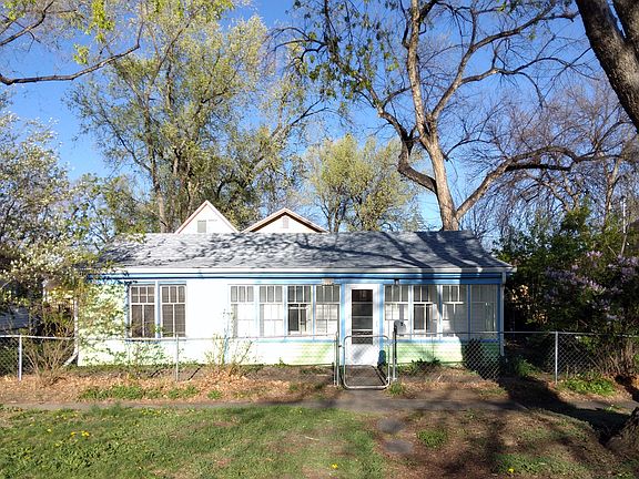 The fenced yard wraps around the front and sides of the house.