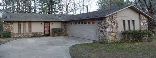Natural stone exterior accents with large, curved driveway
