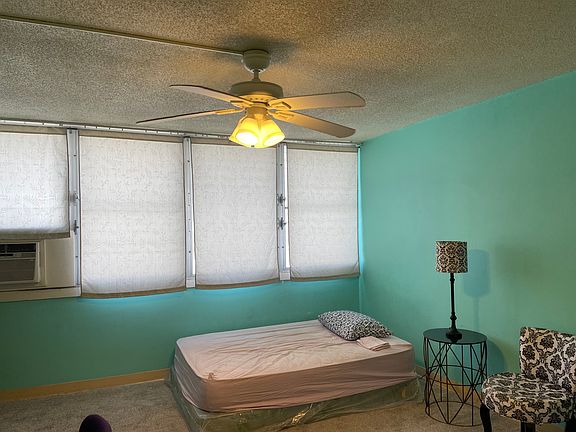 bed, ceiling fan and window AC