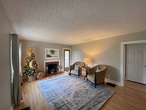 Spacious living room with side door opening to covered side porch.