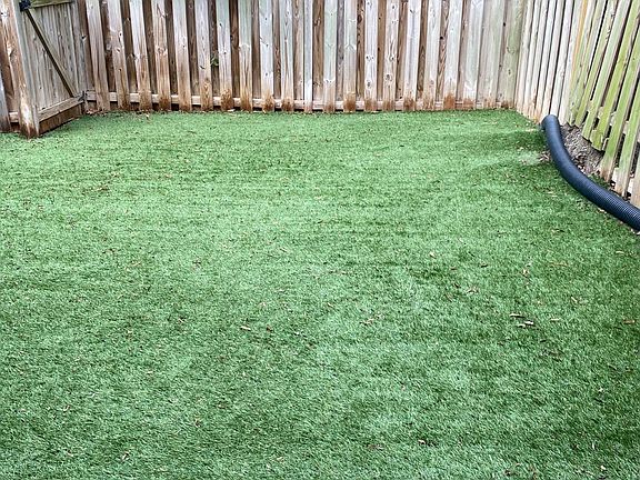 Fully fenced backyard with SynLawn pet turf (part of yard)