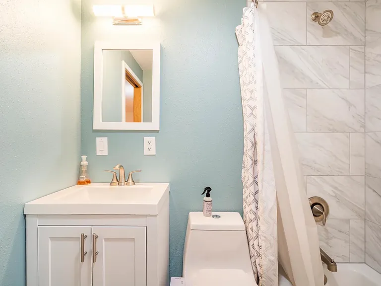 Downstairs full bathroom with shower / tub and new toilet.