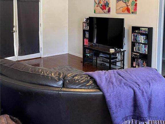 Living room with dark wood-type flooring