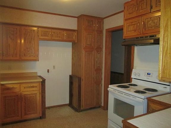Kitchen has solid oak cabinetry with new stove and vinyl floors.