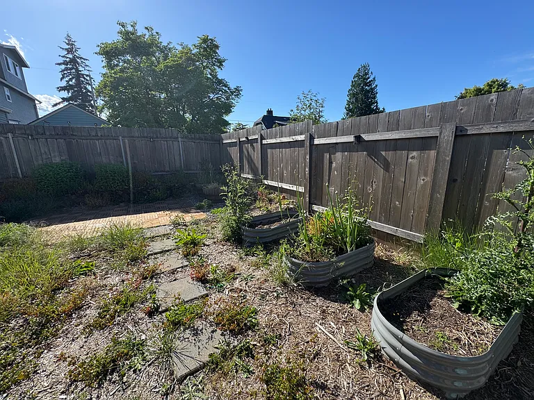 Backyard with seating area and veggie boxes