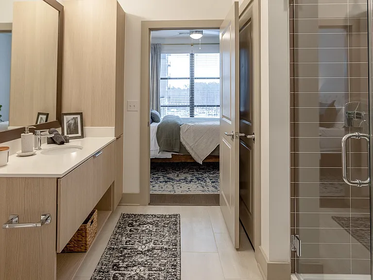Enjoy a sleek bathroom layout with direct access to a sunlit bedroom retreat.