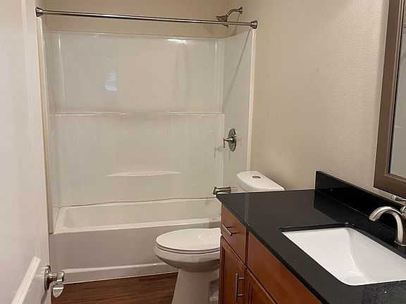 Bright bathroom with full tub and shower, modern vanity, and functional layout.