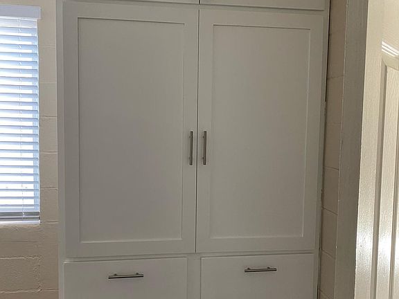 The bedroom has a custom-made, 2-door armoire with several cabinets and drawers for clothes or linen.