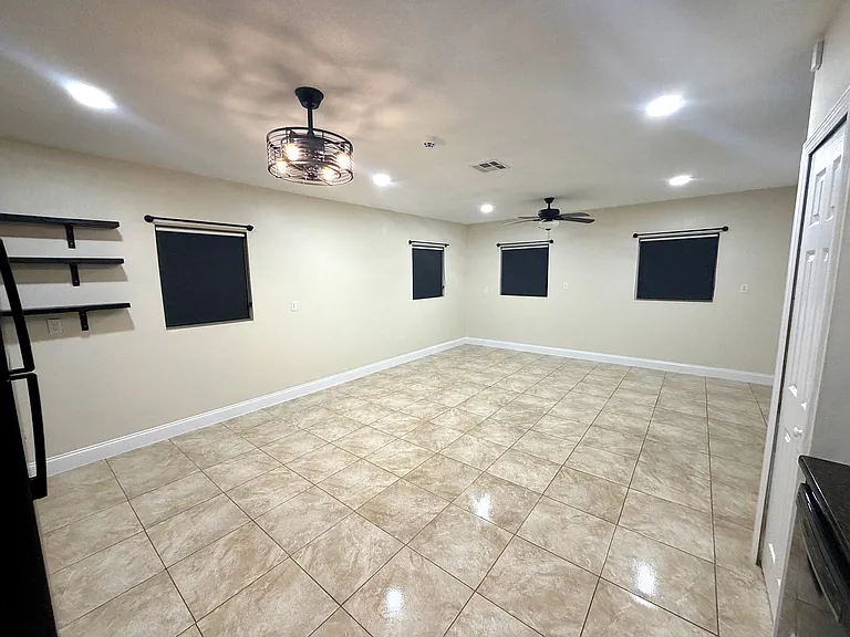 The open_concept living room offers bright windows with blackout shades and warm recessed lighting throughout the space. (Angle 3)