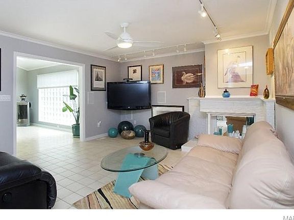 Family room, corner fireplace, tile floor, track lighting