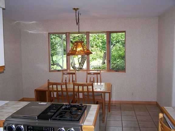 Eating area in kitchen with bay window overlooking back yard.