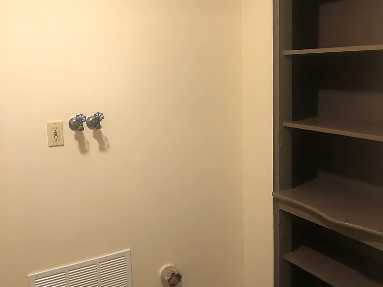 Built-in storage shelves in laundry room.