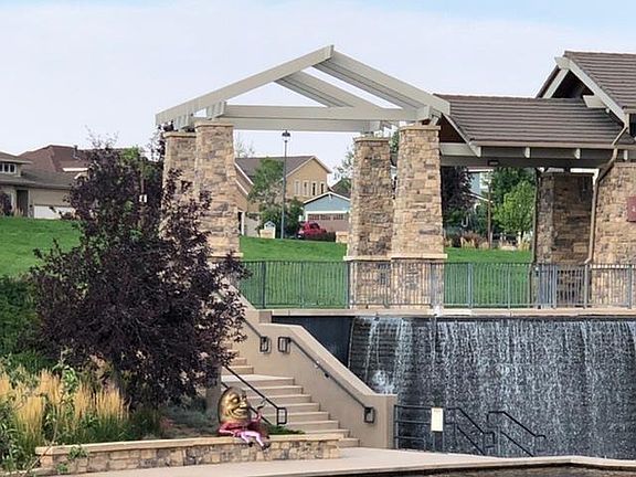 The Wolf Ranch Gateway Park. The house is visible through the arch, the blue one with brown garage doors and red truck in driveway.