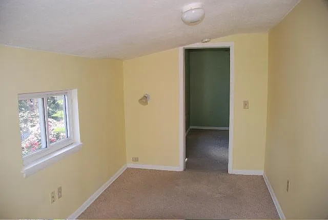 small bedroom, which has a French door to a balcony in the other direction.