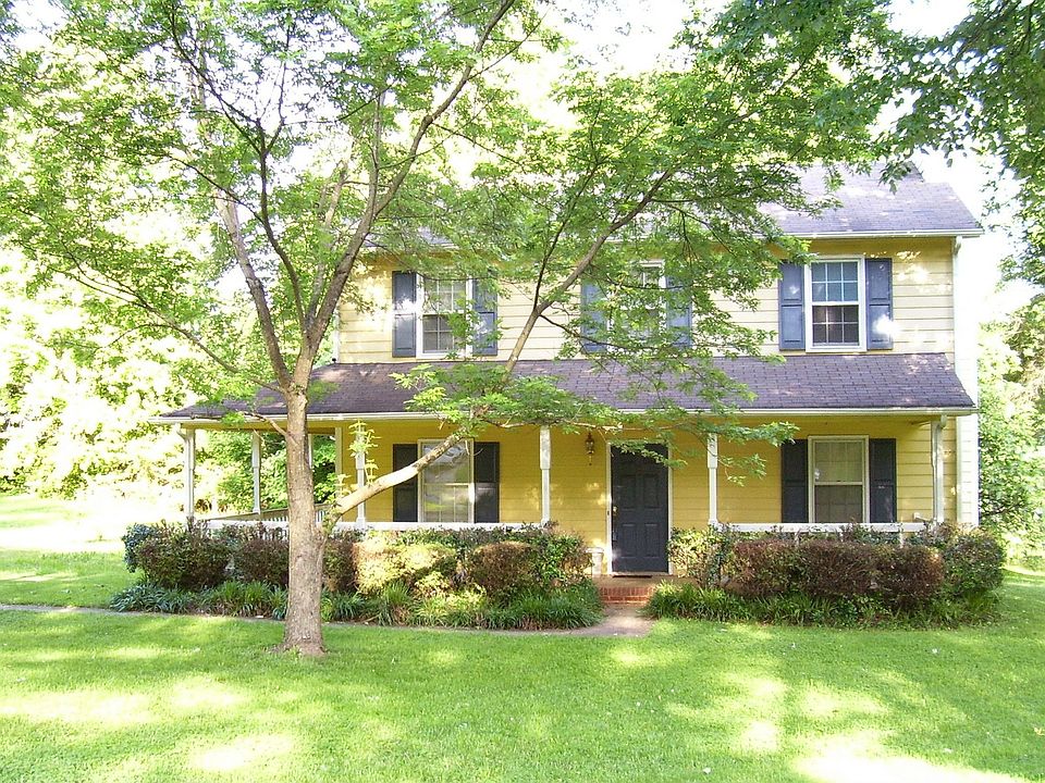 Two story style farmhouse with wrap around porch.