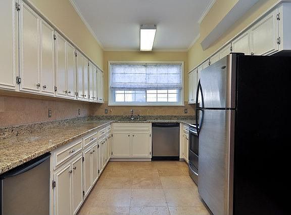 KITCHEN WITH STAINLESS STEEL APPLIANCES AND TRAVERTINE BACKSPLASH