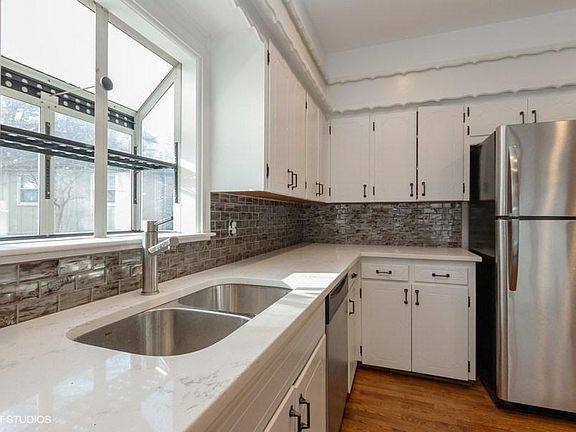 Remodeled house with fine finishes like quartz counters and glass subway tiles with SS appliances.