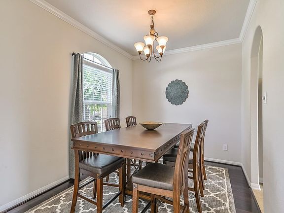 Upgraded Wood Floors, Crown Molding & Arched Window Grace this Dining Room.