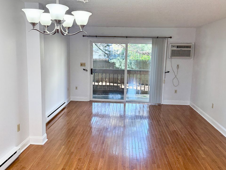 Combination dining & living room with hardwood floors and slider to deck.