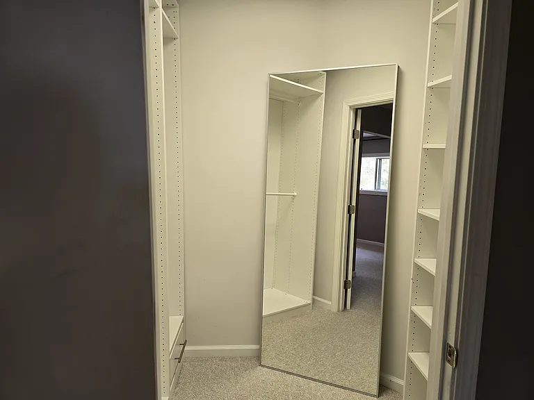 Mirror and lots of shelves in walk-in closet.