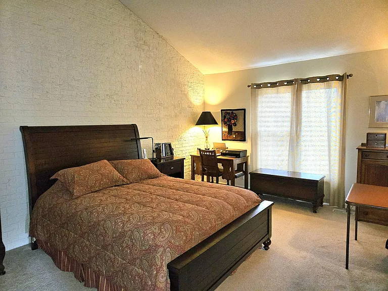 brick accent wall with vaulted ceiling, pond view