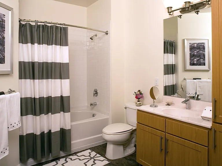 Classic Package bath with oak cabinetry, white quartz countertops, and hard surface flooring