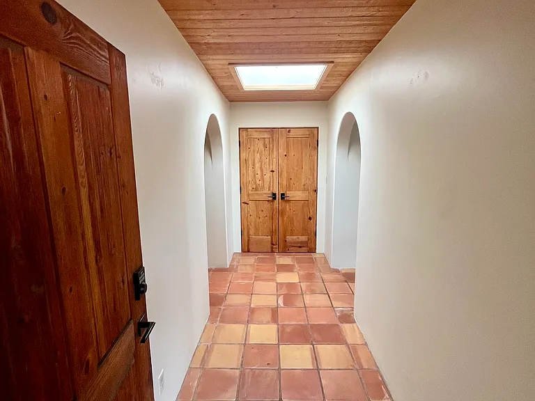 Hallway leading to two bedrooms and updated bathrooms.