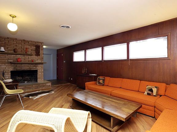 Opposite view towards foyer showing the fireplace and wrap around brick wall.