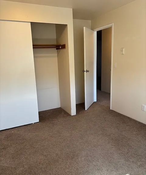 Second bedroom in updated unit, with view of closet with sliding doors