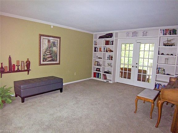 Formal living room with built-in bookshelves. French doors lead to covered porch.