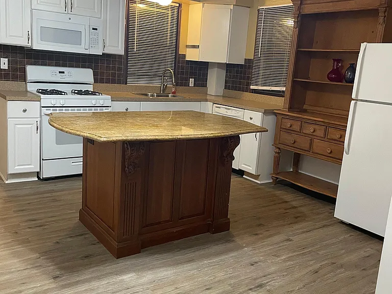 Huge kitchen with all new flooring and large granite island. Has new gas stove and over range microwave. Has dishwasher and fridge with solid wood hutch for bar set-up or dish display.