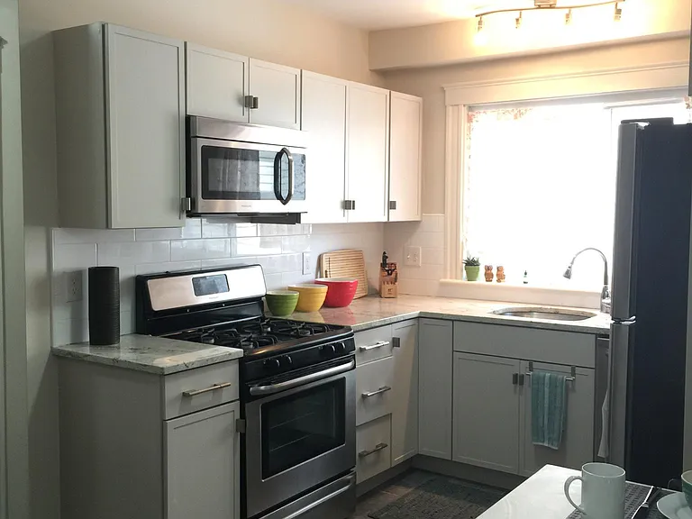 Kitchen has stove, dishwasher, microwave and refrigerator; tiled backsplash and granite countertops; soft close cabinets