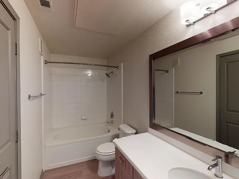 Apartment bathroom with wood-style flooring.
