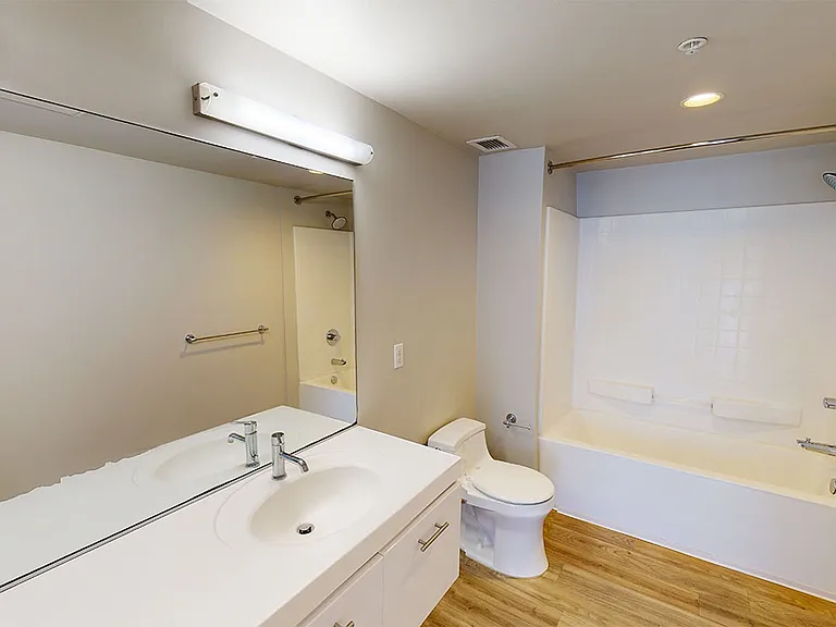 Apartment Bathroom with wood-style flooring.