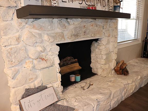 Lime-washed, wood burning fireplace