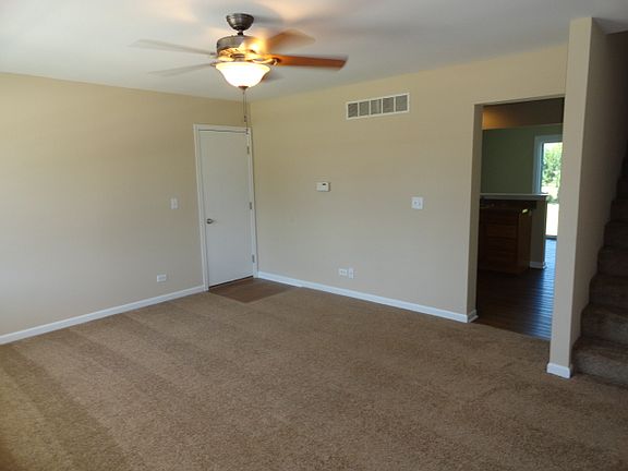 Living room with door going to garage and opening to kitchen
