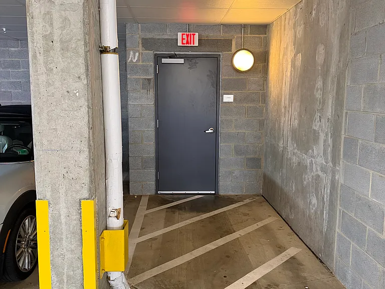 The garage parking space is next to the entrance to the lobby and elevator.