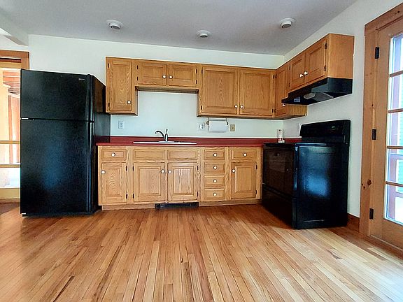 Kitchen with refrigerator, electric glass top stove.