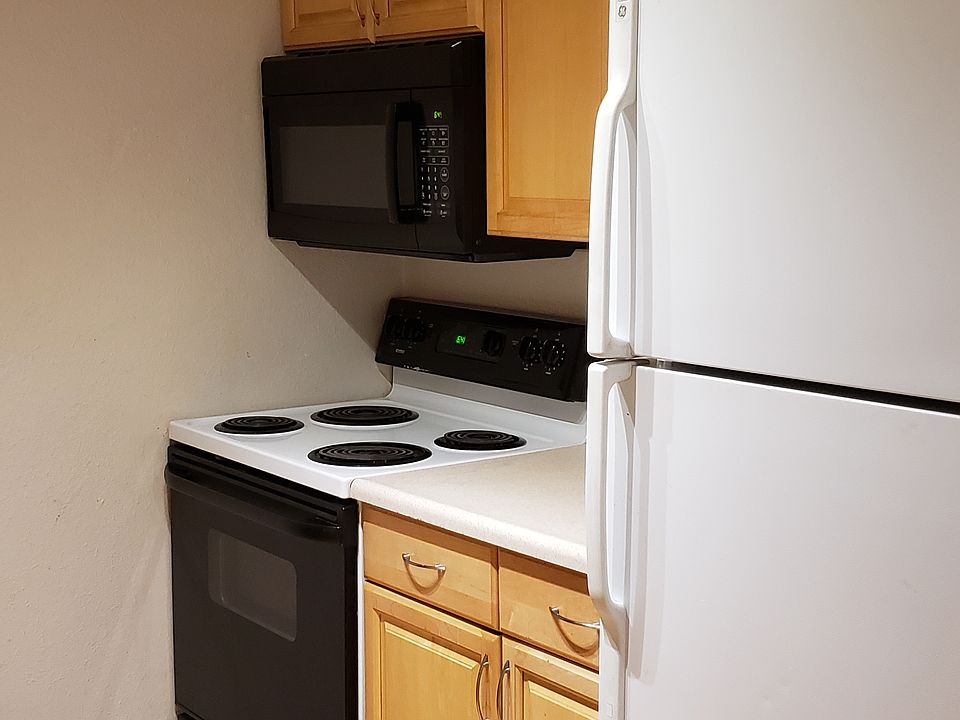 Galley kitchen has microwave, stove/oven, and refrigerator